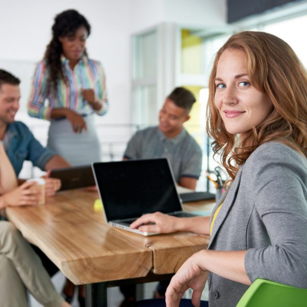 Creative blond businesswoman leading hes team in a friendly conversation about their next agency project